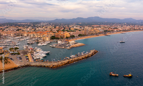 Wallpaper Mural Picturesque aerial view of coastal area of Frejus overlooking marina with moored pleasure yachts and residential districts along waterfront in warm autumn day, France Torontodigital.ca