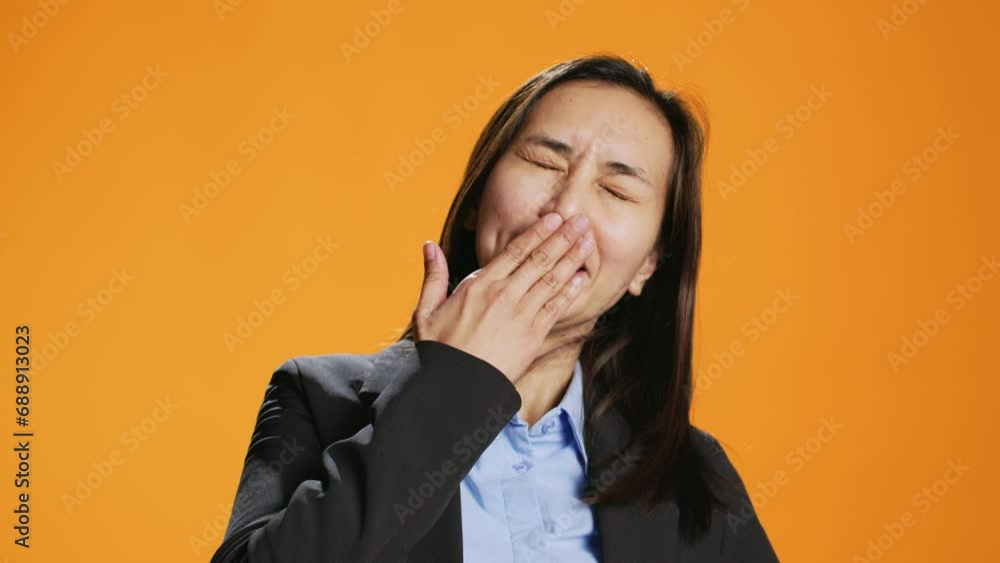 Exhausted person in formal clothes yawning and feeling sleepy in studio, trying to be awake and not fall asleep on camera. Young asian woman being tired and stressed, expressing burnout. Exhausted person in formal clothes yawning and feeling sleepy in studio, trying to be awake and not fall asleep on camera. Young asian woman being tired and stressed, expressing burnout.