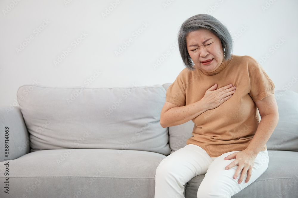 Obraz premium senior woman pain suffering from heart disease on sofa
