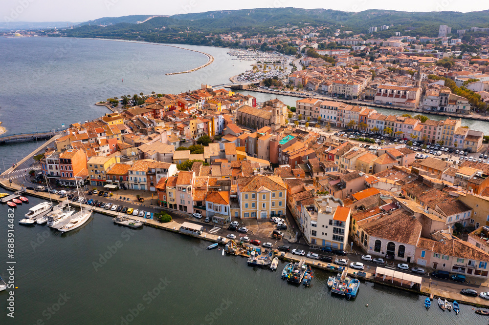 Picturesque aerial view of coastal town of Martigues divided by canals overlooking marina and residential buildings along waterfronts in warm autumn day, France