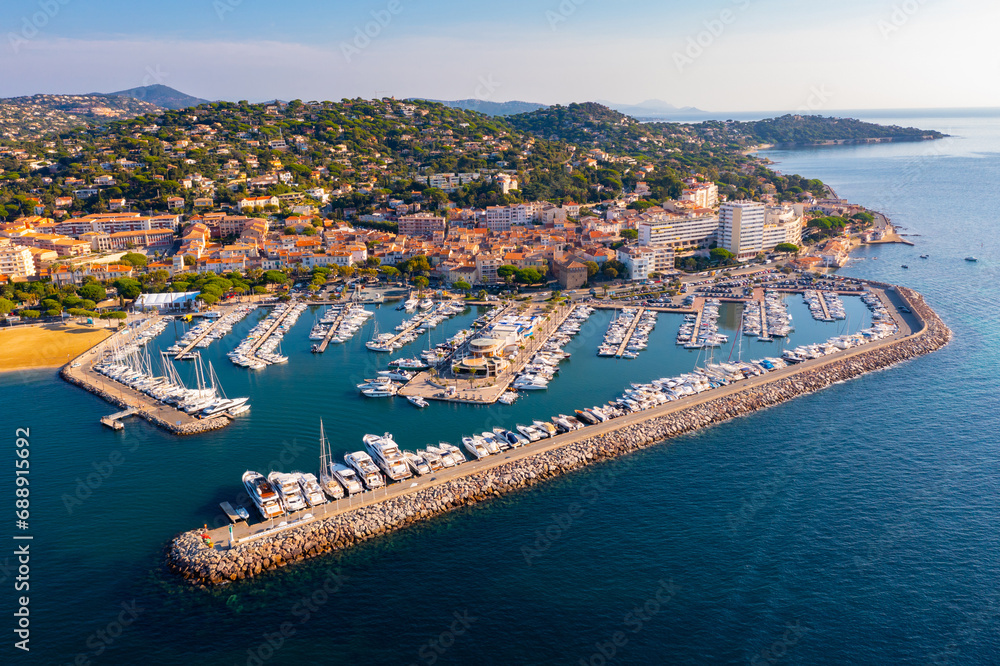 Summer aerial view of French coastal town of Sainte-Maxime on Mediterranean coast overlooking marina with moored pleasure yachts and residential houses on green hills - obrazy, fototapety, plakaty 
