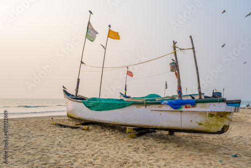 old fishing boats in sand on ocean in India on blue sky background