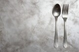 Kitchen silver fork and spoon on flat background with foil texture