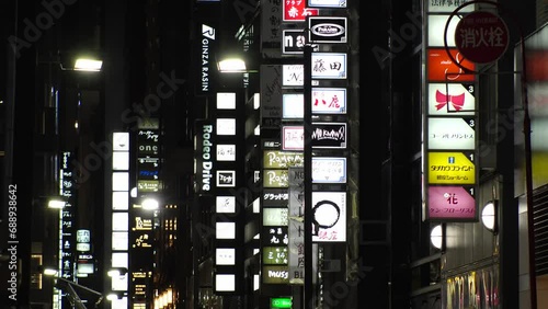 GINZA, TOKYO, JAPAN - NOV 2023 : View of Ginza area at night. Famous upmarket shopping, dining and entertainment district, featuring numerous department stores, restaurants, night clubs and cafes. photo