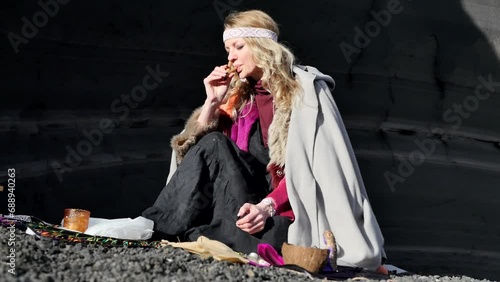 Meditative practice of Rape: A young beautiful shaman woman dressed in beautiful colorful clothes and beaded jewelry blew a herbal tobacco mixture into her nostril using a special pipe. Peruvian rite photo