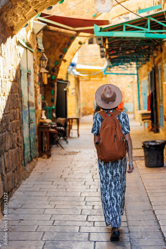 Beautiful traveler girl wearing a hat and backpack exploring the historical city of Acre in Israel. .View of Akko  Acre   Israel.