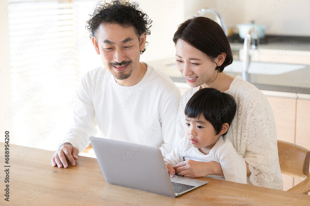 ダイニングでパソコンを使う家族のクローズアップ左にコピースペースあり ダイニングでパソコンを使う家族のクローズアップ左にコピースペースあり