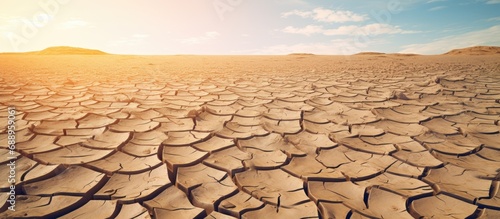 The photo shows cracked dry land due to drought, causing desertification.