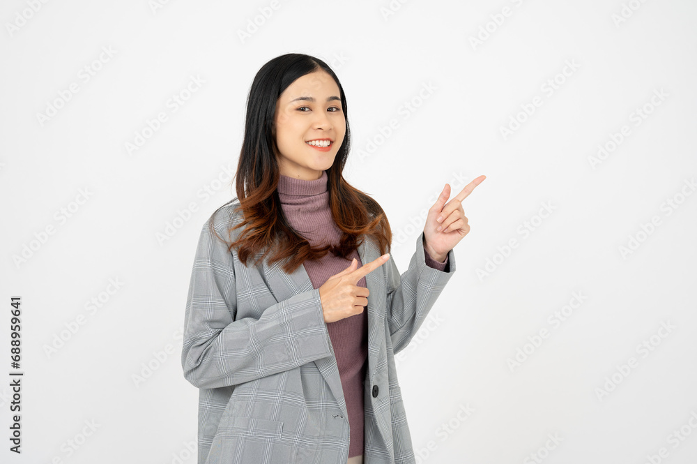 Young asian business woman, smiling while pointing finger, standing over white background. Young asian business woman, smiling while pointing finger, standing over white background.