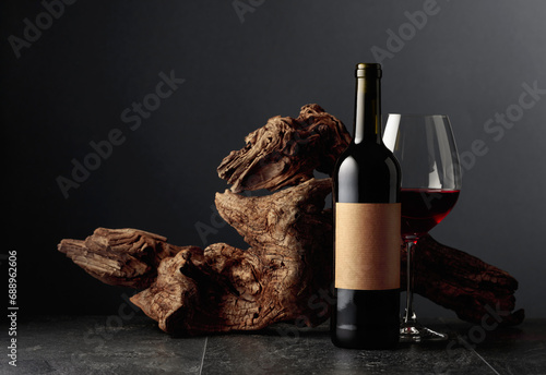 Bottle and glass of red wine with old empty label.