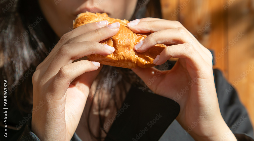 Young caucasian woman eating croissant. Young caucasian woman eating croissant.