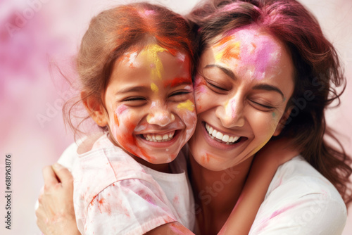 Indian ethnic mother and daughter having fun by celebrating Holi festival with colours 
