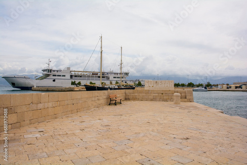 The harbour sign and a ferry in Supetar port on Brac Island in Croatia. The text says "Turn the key of St. Peter and the location of paradise will be revealed to you" © dragoncello