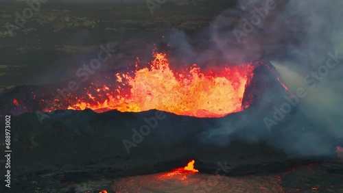 Aerial drone view over active volcanic crater eruption. Hot lava and magma coming out of the crater. Tourist attraction in Iceland Litli-Hrútur eruption 2023. Beautiful and dangerous disaster. photo