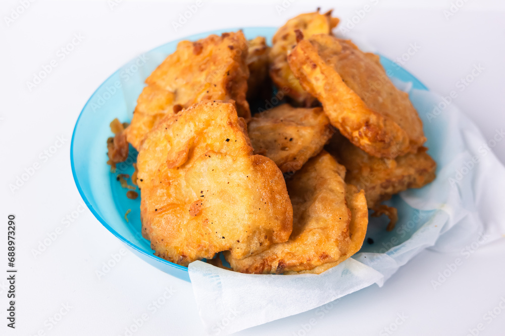 Flour fried tempeh on a blue plastic plate isolated on a white background Flour fried tempeh on a blue plastic plate isolated on a white background