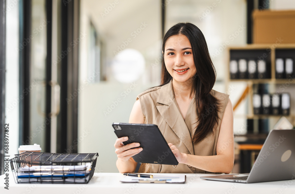 A focused Asian freelance writer takes notes at her desk with a laptop in a bright, modern office setting, journalist, artist, portrait, Thai's people. A focused Asian freelance writer takes notes at her desk with a laptop in a bright, modern office setting, journalist, artist, portrait, Thai's people.