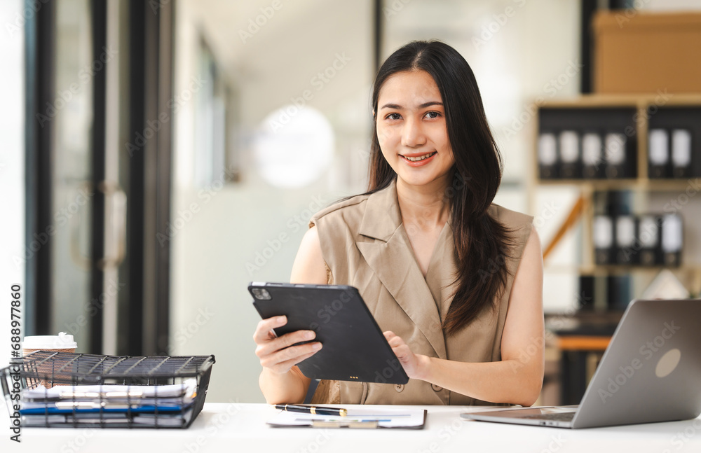 A focused Asian freelance writer takes notes at her desk with a laptop in a bright, modern office setting, journalist, artist, portrait, Thai's people. A focused Asian freelance writer takes notes at her desk with a laptop in a bright, modern office setting, journalist, artist, portrait, Thai's people.