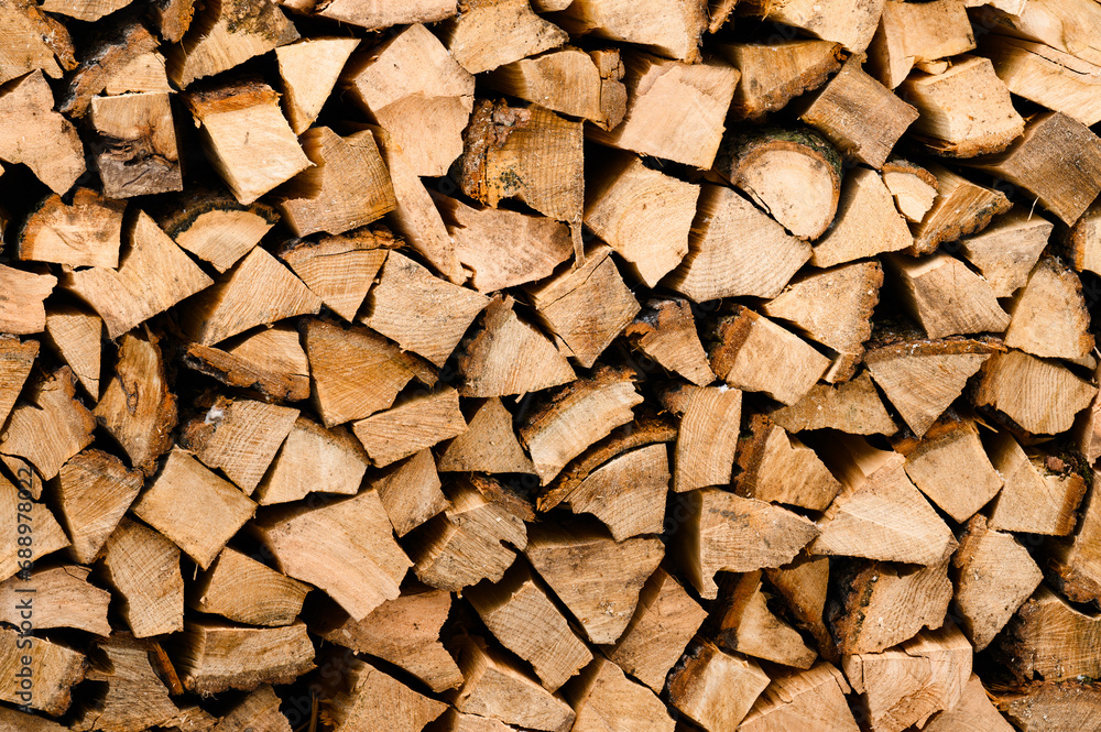 Chopped firewood is stacked vertically in a container. Texture with a background of chopped firewood in brown color. Chopped firewood is stacked vertically in a container. Texture with a background of chopped firewood in brown color.