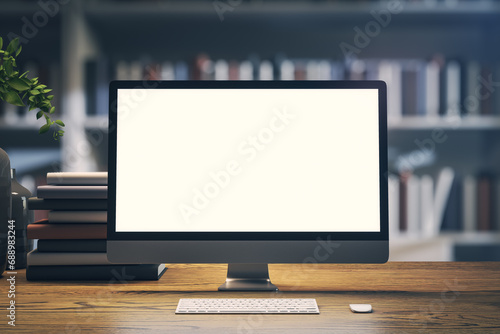 Modern computer monitor with white screen, mockup for design on library table. 3D Rendering