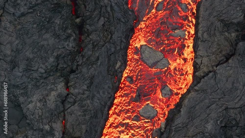 Aerial drone view over river of molten hot lava erupting from the Litlihrutur Iceland volcano and flows through dark rock in 2023. Tourist attraction to beautiful and dangerous disaster. photo