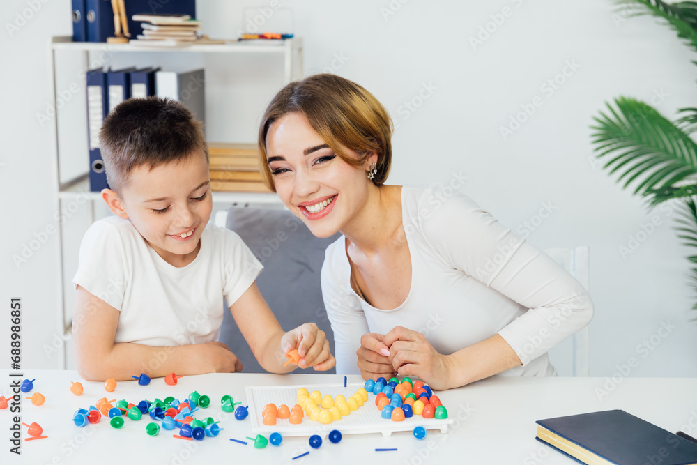 Fototapeta premium Female psychologist playing educational games with boy