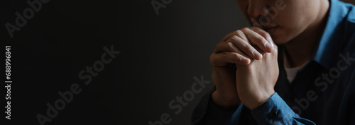 A young man sits and prays to God. with faith and faith Religious concepts and belief in God Pray for the strength of hope or love from God. photo
