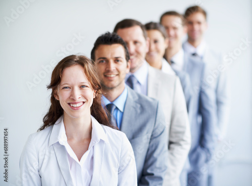 Woman, portrait and leader in interview row, employees and ready for selection process. Worker, corporate accountant in suit or professional in workplace, colleagues in background and confident © Mariusz S/peopleimages.com