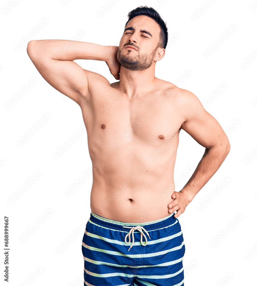 Fototapeta premium Young handsome man wearing swimwear suffering of neck ache injury, touching neck with hand, muscular pain