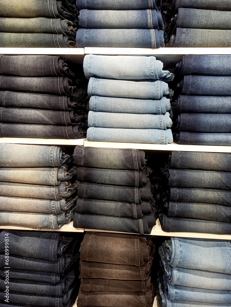 Jeans pants of colorful shades in stack