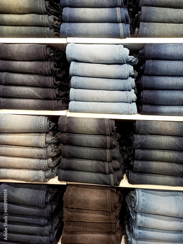 Jeans pants of colorful shades in stack