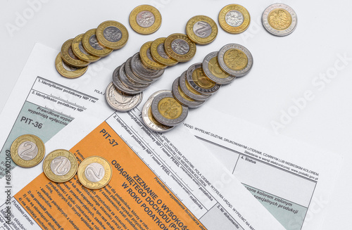 Formularz podatkowy Pit 37 i stos przewróconych monet