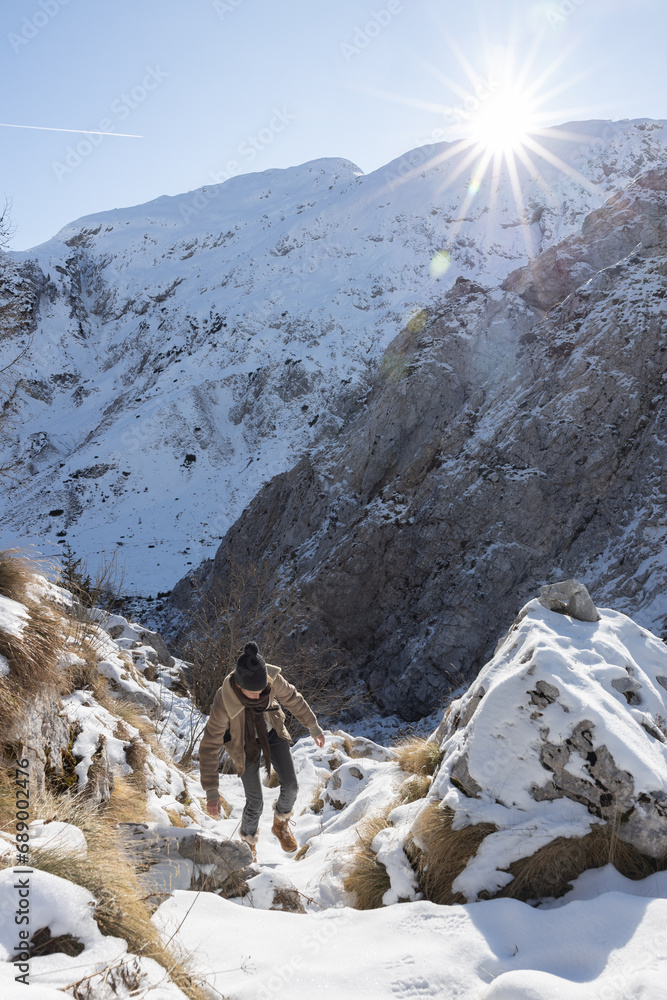 Snowy Mountain Trail Hike: Adult Woman Treks as Sun Sets Behind Surrounding Peaks