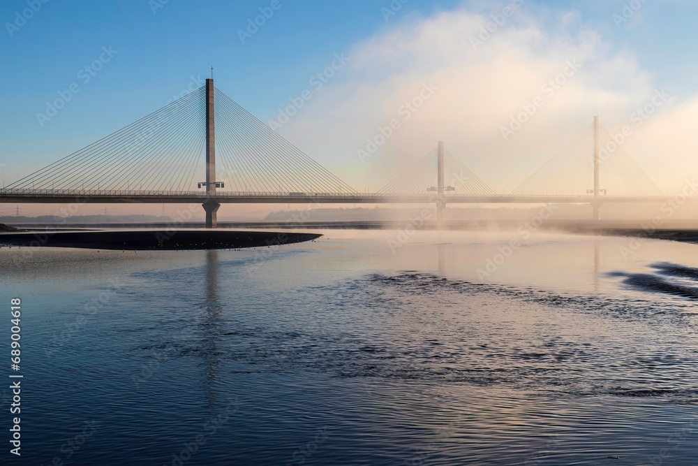 Cable-Stayed River Crossing Mersey Gateway Bridge in winter with fog