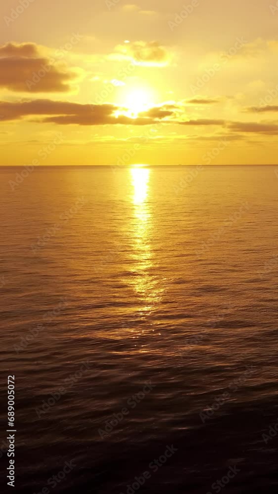 Sea water surface at sunset. Vertical aerial view, camera flies over calm golden sea. Sun glare. Abstract nautical summer ocean nature. Holiday and travel concept. Nobody. Weather and climate change Sea water surface at sunset. Vertical aerial view, camera flies over calm golden sea. Sun glare. Abstract nautical summer ocean nature. Holiday and travel concept. Nobody. Weather and climate change
