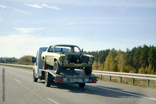 Recover a Retro Car After an Accident. A Project to Restore a Classic Car with the Help of a Tow Truck. A Vintage Car Damaged by a Collision on the Highway.