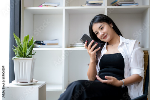 Young asian woman using smart while relaxing at resting corner.