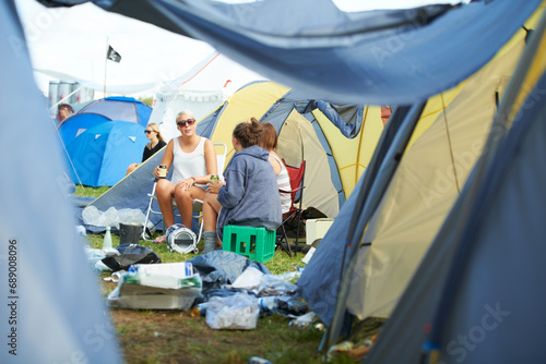 Camping, tent and friends with drinks at a festival, event or group in conversation with garbage on ground. People, talking and relax with beer at party in summer, vacation or travel on holiday © Mariusz S/peopleimages.com
