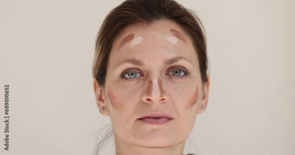 Close-up samples with foundation on a young female face. Beauty model, applying color, slowmotion Close-up samples with foundation on a young female face. Beauty model, applying color, slowmotion