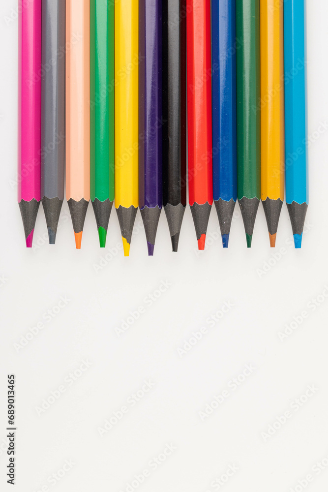Wooden color pencils arranged in row on white isolated background. Selective focus Wooden color pencils arranged in row on white isolated background. Selective focus