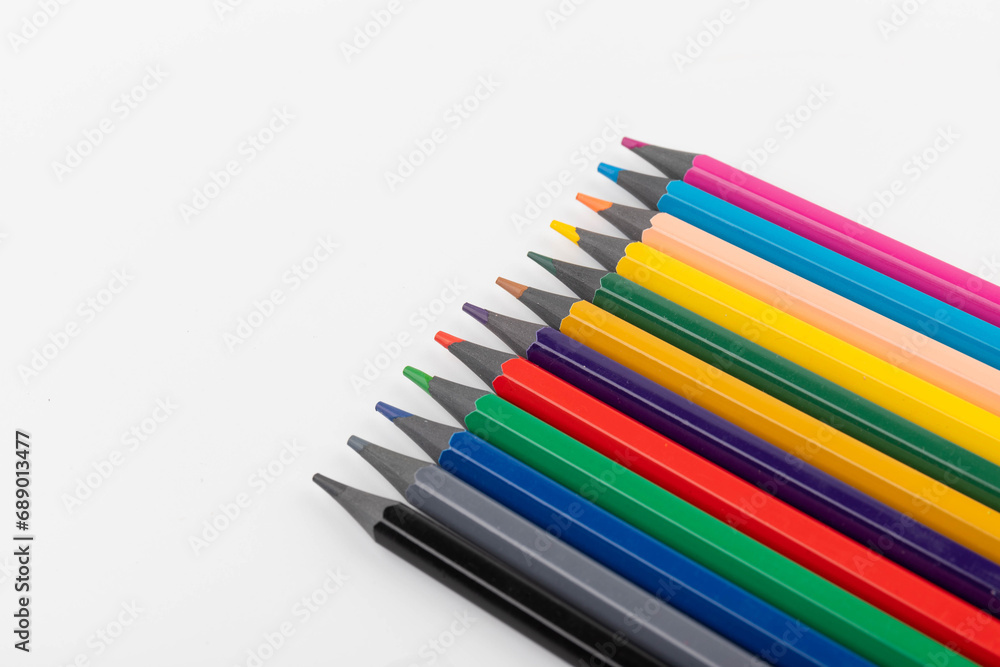 Wooden color pencils arranged in row on white isolated background. Selective focus Wooden color pencils arranged in row on white isolated background. Selective focus