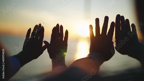 Human adult child hands touch window. Four hands on window glass, view on golden sunset over sea. People admiring evening enjoying nature on boat, ship, yacht. Travelling tourism on water transport. photo