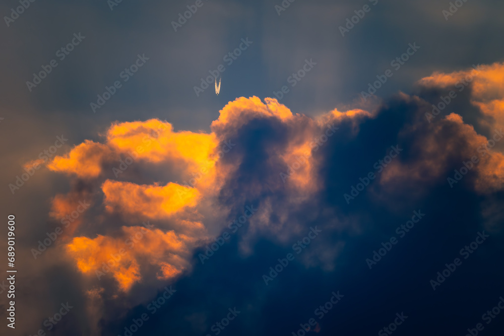 夕暮れ雲に入る飛行機雲20231203