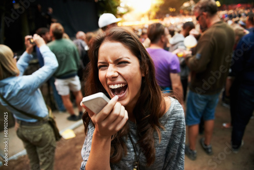 Music festival, concert and woman outdoor with phone call, shouting or energy at rave party with crowd at event. Contact, person and loud voice, sound or screaming conversation at smartphone to hear photo