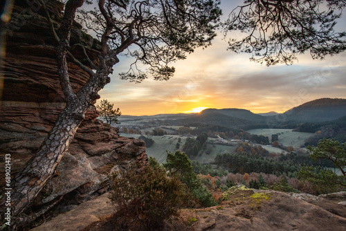 Hilly landscape shot on a sandstone rock in the forest. Cold morning mood at sunrise at a viewpoint. Winter morning in Palatinate Forest, Germany © Jan