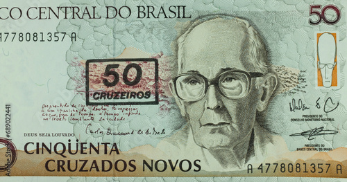 Imagen de la parte de un billete de 50 cruzeiros del Banco de Brasil. Retrato de Carlos Drummond de Andrade (1902-1987), con las casas y montañas de Itabira