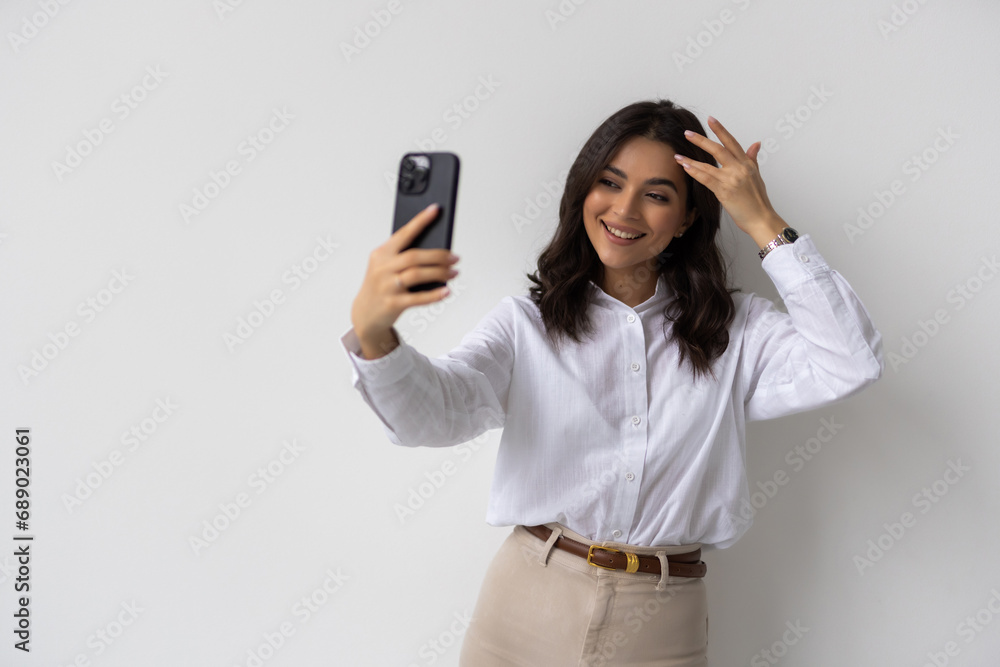 Portrait of a smiling businesswoman taking selfie with mobile phone isolated over white background Portrait of a smiling businesswoman taking selfie with mobile phone isolated over white background