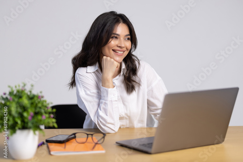 Confident businesswoman working on laptop at her workplace at modern office.