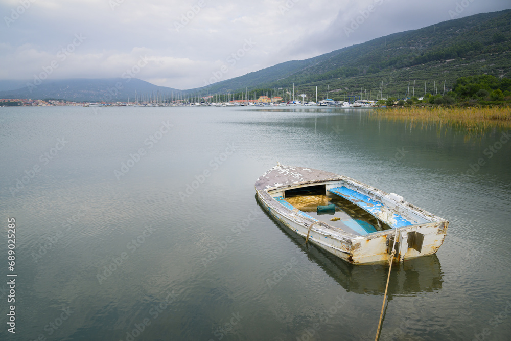 Small shabby boat in a bay of Cres