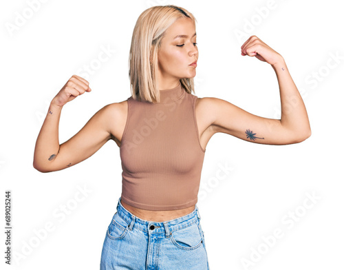 Beautiful young blonde woman wearing casual style with sleeveless shirt showing arms muscles smiling proud. fitness concept.