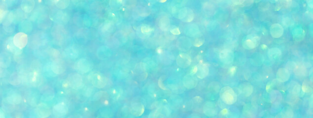 Blurred shiny turquoise background with sparkling lights.